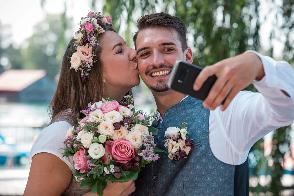 Hochzeitspaar macht Selfie, Paarshooting mit Tracht in Bayern